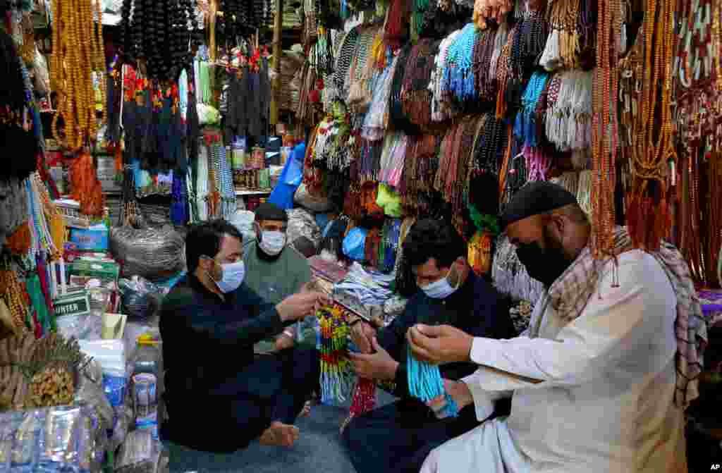 خرید و فروش تسبیح، کلاه سنتی و سایر اقلام برای ماه رمضان در یک مغازه در پیشاور، پاکستان
