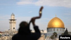 Seorang pria terlihat seperti siluet saat dia meniup Shofar, sebuah tanduk ram, dengan latar belakang Dome of the Rock (kanan), di Kota Tua Yerusalem, kompleks yang dikenal oleh Muslim sebagai Tempat Suci dan Yahudi sebagai Temple Mount, 10 Desember 2017. (Foto: dok).