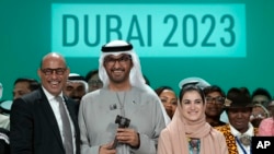 FILE - United Nations Climate Chief Simon Stiell, from left, COP28 President Sultan al-Jaber and Hana Al-Hashimi, chief COP28 negotiator for the United Arab Emirates, pose for photos at the end of the COP28 U.N. Climate Summit, December 13, 2023, in Dubai, United Arab Emirates.