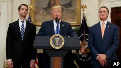 President Donald Trump, flanked by Sen. Tom Cotton, R- Ark., left, and Sen. David Perdue, R-Ga., speaks in the Roosevelt Room of the White House in Washington, Aug. 2, 2017, during the unveiling of legislation that would place new limits on legal immigrat