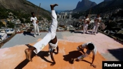 Members of the Acorda Capoeira (Awaken Capoeira) group perform on a rooftop in the Rocinha favela in Rio de Janeiro, Brazil, July 24, 2016.