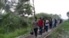 FILE - Migrants walk on train tracks on their journey from Central America to the U.S. border., in Palenque, Chiapas state, Mexico, Feb. 10, 2021. 