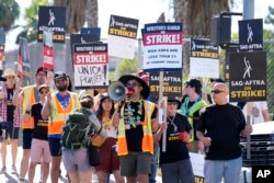 Striking writers and actors take part in a rally outside Netflix studio in Los Angeles on Friday, July 14, 2023, the day actors formally joined the picket lines, more than two months after screenwriters began striking for better pay and working conditions. (AP Photo/Chris Pizzello)