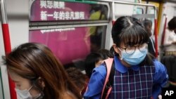 Para penumpang kereta api bawah tanah di Hong Kong, mengenakan masker sebagai tindakan preventif menghadapi virus corona yang disinyalir mulai merebak di China, 7 Januari 2020. 