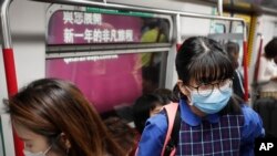Commuters wear protection masks inside a subway train in Hong Kong, Jan. 7, 2020, thanks to a mysterious respiratory illness whose cause is unknown. 