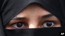 FILE - A veiled Iranian woman attends a rally after the Friday prayers in Tehran, Iran.