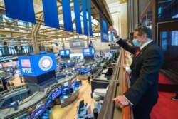 FILE - New York Gov. Andrew Cuomo rings the opening bell at the New York Stock Exchange as the building opens for the first time since March amid the outbreak of the coronavirus disease, in Manhattan, New York, May 26, 2020.