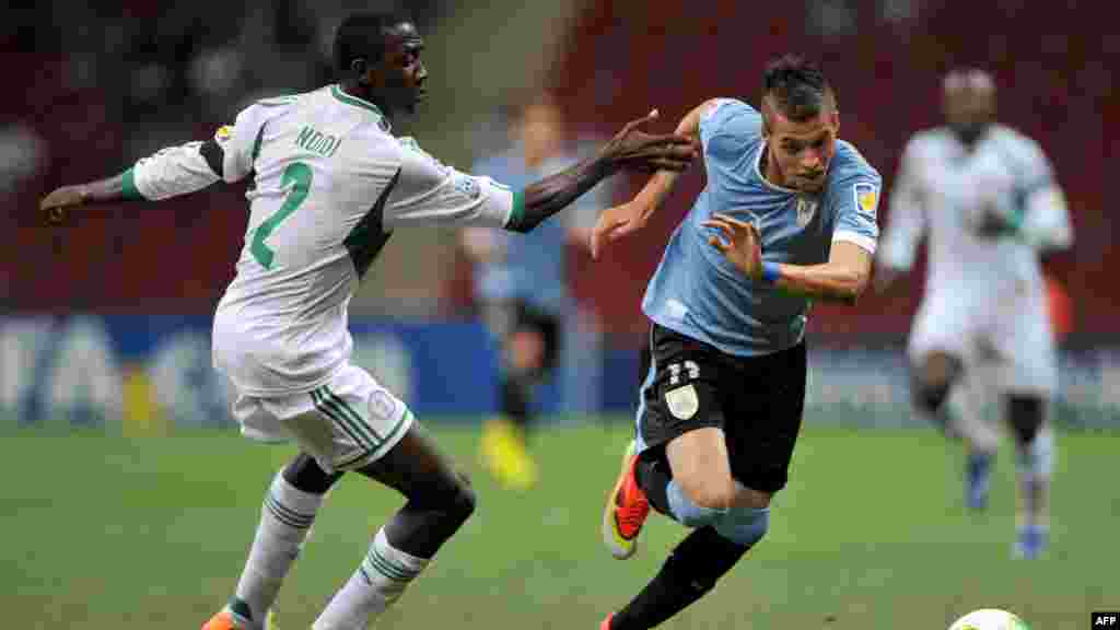 L&#39;attaquant uruguayen Nicolas Lopez affronte le défenseur nigérian Wilfred Onyinye Ndidi lors du 16e match de football entre le Nigeria et l&#39;Uruguay lors de la Coupe du Monde des moins de 20 ans au stade TT Arena à Istanbul le 2 juillet 2013.