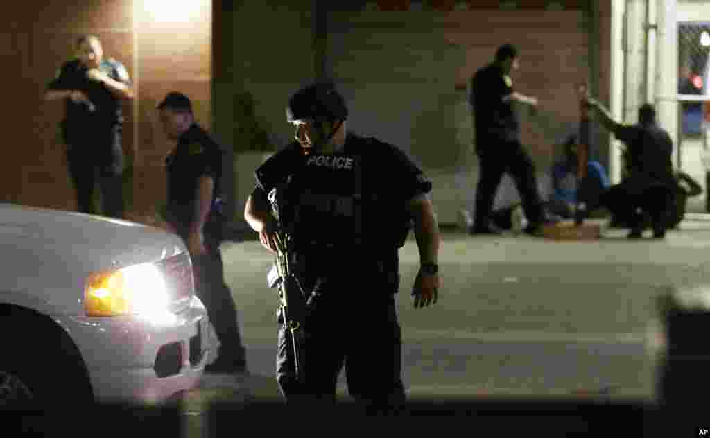 Dallas police detain a driver after several police officers were shot in downtown Dallas on July 7, 2016. Snipers apparently shot police officers during protests and some of the officers are dead, the city's police chief said in a statement.