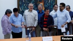 FILE - Revolutionary Armed Forces of Colombia (FARC) commander, Timoleon Jimenez (2nd L), talks to Pablo Beltran, (L) representative of Colombian National Liberation Army (ELN) during a joint news conference in Havana, Cuba, May 11, 2017. 