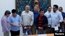 Revolutionary Armed Forces of Colombia (FARC) commander, Timoleon Jimenez (2nd L), talks to Pablo Beltran, (L) representative of Colombian National Liberation Army (ELN) during a joint news conference in Havana, Cuba, May 11, 2017. 