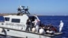 Migrants are evacuated by Italian Coast guards from the Open Arms Spanish humanitarian boat at the coasts of the Sicilian island of Lampedusa, southern Italy, Aug.17, 2019.