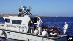 Migrants are evacuated by Italian Coast guards from the Open Arms Spanish humanitarian boat at the coasts of the Sicilian island of Lampedusa, southern Italy, Aug.17, 2019.