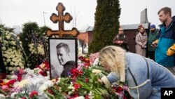 Một người phụ nữ đặt hoa trước mộ Alexei Navalny một ngày sau đám tang của ông tại Nghĩa trang Borisovskoye, ở Moscow, Nga, vào thứ Bảy, ngày 2 tháng 3 năm 2024. 