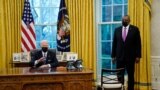 Secretary of Defense Lloyd Austin listens as President Joe Biden speaks before signing an Executive Order reversing the Trump era ban on transgender people serving in the military, in the Oval Office of the White House, Jan. 25, 2021.