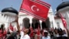 An Acehnese man waves a Crescent-Star flag during a rally outside Baiturrahman Grand Mosque in Banda Aceh, Aceh province, Indonesia, April 1, 2013.