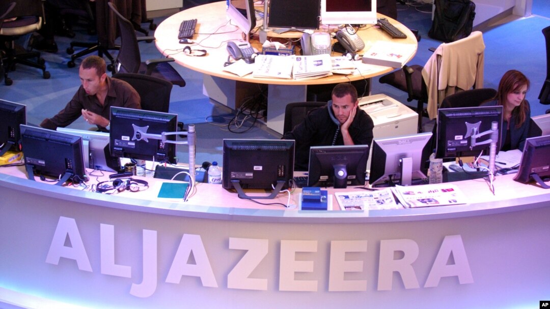 FILE - Al Jazeera English Channel staff prepare for the broadcast in Doha news room in Qatar.
