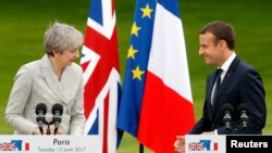 Presiden Perancis Emmanuel Macron (kanan) bersama PM Inggris Theresa May saat bertemu di Istana Elysee, Paris, Perancis, 13 Juni 2017. (Foto: dok).