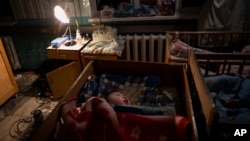 Orphaned children sleep inside cribs at the children's regional hospital maternity ward in Kherson, southern Ukraine, Tuesday, Nov. 22, 2022.