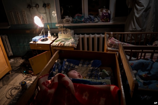 Orphaned children sleep inside cribs at the children's regional hospital maternity ward in Kherson, southern Ukraine on November 22, 2022. (AP Photo/Bernat Armangue)