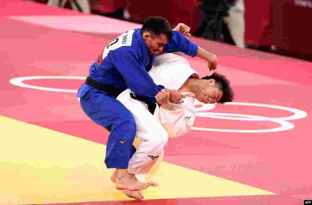 Pejudo Jepang Hifumi Abe (kanan, putih) mencoba menjatuhkan pejudo Georgia, Vazha Margvelashvili (kiri) dalam pertandingan final judo putra kelas 66kg pada Olimpiade Tokyo 2020 di Nippon Budokan, Minggu 25 Juli 2021. (Foto: AFP)