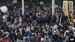 Police officers are surrounded by protesters at the Hong Kong Government Headquarters in Hong Kong, Jan. 1, 2018.