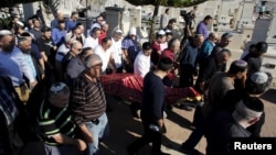 The body of Reuven Aviram, 51, one of two people killed Nov. 19 in a Palestinian stabbing attack in Tel Aviv, is carried by friends and relatives during his funeral in Ramle, Israel, Nov. 20, 2015.