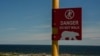 A young man watches for potential polar bears while walking near the Hudson Bay, Aug. 3, 2024, in Churchill, Manitoba. 