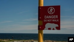 Seorang pria sedang memperhatikan kemungkinan kemunculan beruang kutub di dekat Teluk Hudson, di Churchill, Manitoba, Kanada, 3 Agustus 2024. (Foto: Joshua A. Bickel/AP Photo)