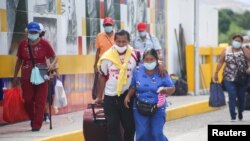 Las personas, autorizadas por razones humanitarias, llegan por el puente internacional Simón Bolívar desde Cúcuta, Colombia, cuando se vuelve abrir el cruce en San Antonio del Táchira, Venezuela, el 4 de octubre de 2021.