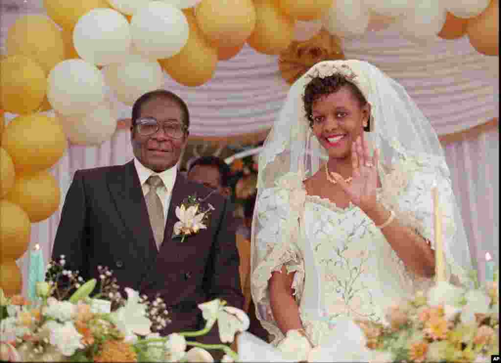 Grace Marufu, pengantin Presiden Robert Mugabe, kanan, melambaikan tangan kepada tamu-tamu, 17 Agustus 1996, setelah upacara pemberkatan perkawinan di misi Katolik Kutama, 42 mil (80 km) barat Harare. (AP Photo)