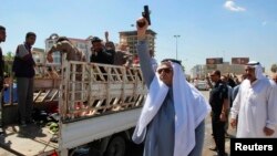 A man fires a gun during a funeral for protesters who died during a clash between Iraqi forces and Sunni Muslim protesters in Kirkuk, 250 km north of Baghdad Apr. 24, 2013.