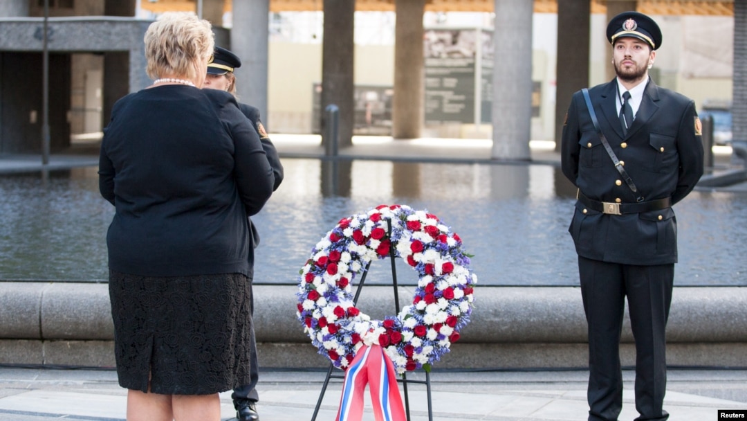 Norway's Prime Minister Erna Solberg, left, attends a wreath-laying ceremony near the government building that was bombed four years ago by gunman Anders Behring Breivik in Oslo, July 22, 2015. 