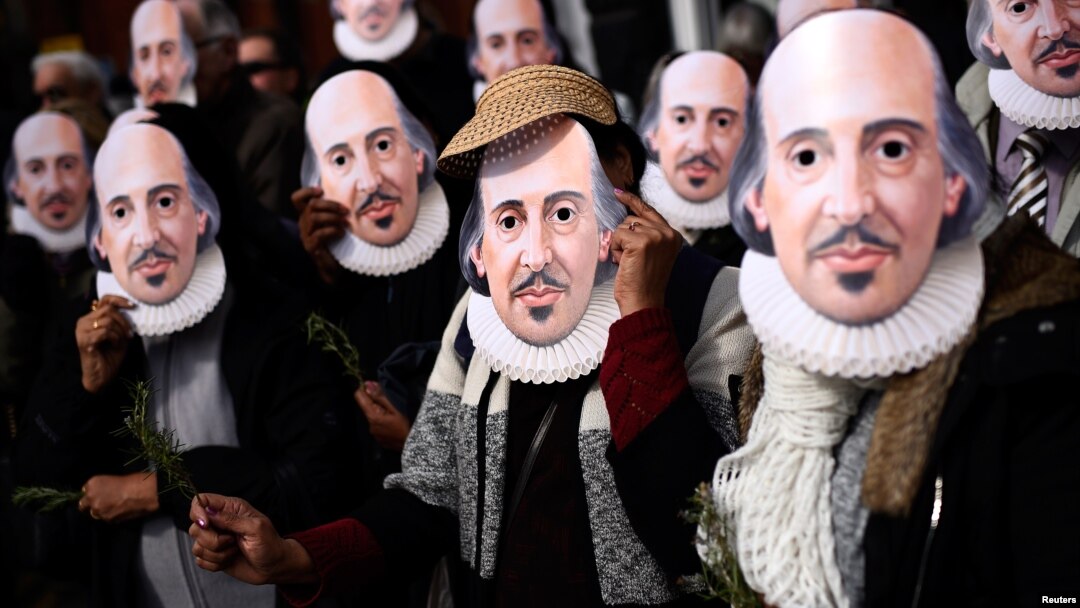 Warga mengenang topeng bergambar foto William Shakespeare pada peringatan 400 tahun kematiannya jalan-jalan Stratford-Upon-Avon, kota kelahirannya di Inggris, Sabtu (23/4).