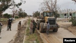 FILE - Members of East Libyan forces open Tripoli road after they captured the final holdout of Islamist-led rivals in the southwest of Benghazi, Libya, March 21, 2017. On Saturday, they took control of the central Souq al-Hout neighborhood of Benghazi. 