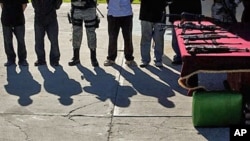 FILE - Suspected members of Sinaloa drug cartel and weapons are presented to the media in Tijuana, Mexico, Jan. 20, 2011. The U.S. Treasury Department imposed sanctions July 1, 2024, against three individuals accused of laundering money for the Sinaloa cartel. 