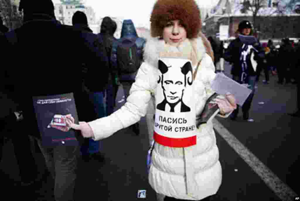 A young activist who says she will work as an observer during the upcoming presidential election has a sign with a portrait of Vladimir Putin with horns that reads, "Go to pasture in another country!", February 4, 2012. (VOA - Y. Weeks)