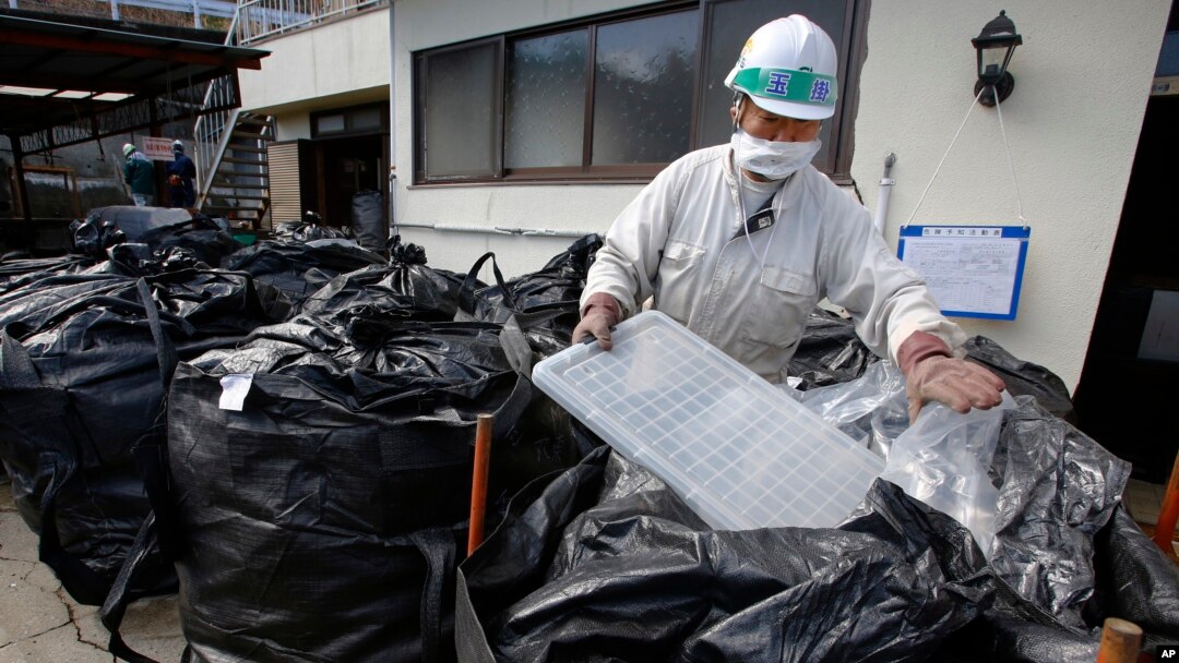 Radioaktiv chiqindilarni yig'ayotgan ishchi, Fukushima, Yaponiya