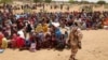 Sudanese refugees, who have fled the violence in their country, wait to receive food rations from the World Food Program, near the border between Sudan and Chad, in Koufroun, Chad May 9, 2023. 