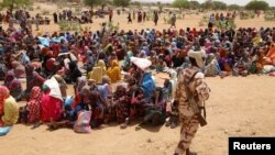 Sudanese refugees, who have fled the violence in their country, wait to receive food rations from the World Food Program, near the border between Sudan and Chad, in Koufroun, Chad May 9, 2023. 