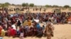 Pengungsi Sudan, yang melarikan diri dari kekerasan di negaranya, menunggu untuk menerima jatah makanan dari Program Pangan Dunia (WFP), di dekat perbatasan antara Sudan dan Chad, di Koufroun, Chad, 9 Mei 2023. (Foto: REUTERS/Zohra Bensemra )