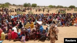 Pengungsi Sudan, yang melarikan diri dari kekerasan di negaranya, menunggu untuk menerima jatah makanan dari Program Pangan Dunia (WFP), di dekat perbatasan antara Sudan dan Chad, di Koufroun, Chad, 9 Mei 2023. (Foto: REUTERS/Zohra Bensemra )