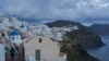 Un turista se acerca a las iglesias ortodoxas con cúpulas azules en la ciudad de Oia, en la isla de Santorini, Grecia, afectada por un terremoto, el 4 de febrero de 2025. AP