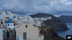 Un turista se acerca a las iglesias ortodoxas con cúpulas azules en la ciudad de Oia, en la isla de Santorini, Grecia, afectada por un terremoto, el 4 de febrero de 2025. AP