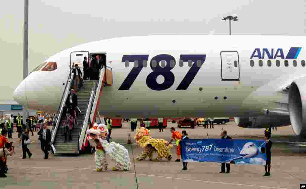 Passengers of a Boeing 787 are welcomed by lion dance to celebrate the airplane's inaugural commercial flight from Japan, at Hong Kong International Airport, October 26, 2011. 