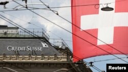 FILE PHOTO: Switzerland's national flag flies in front of the headquarters of Swiss bank Credit Suisse in Zurich