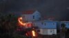 Lava dari gunung berapi Cumbre Vieja tampak membakar beberapa rumah di Pulau Canary, Kepulauan La Palma, Spanyol, pada 19 Oktober 2021. (Foto: Reuters/Susana Vera)