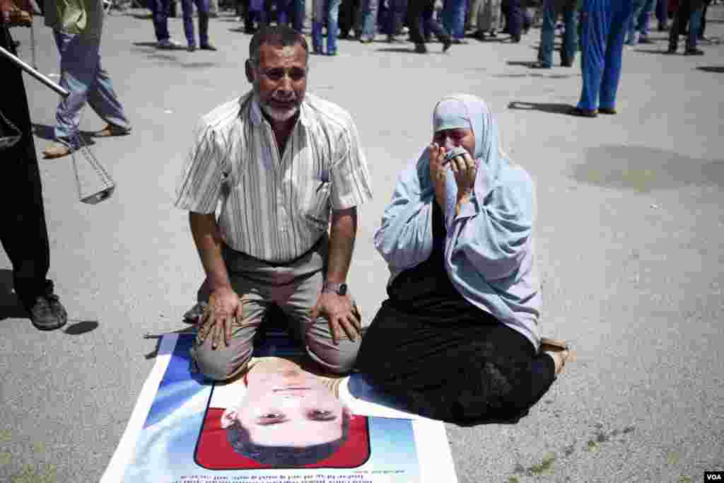 A couple honors one the protesters killed during the uprising, June 2, 2012. (VOA/Y. Weeks)