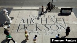 FILE - People walk past a tribute to Michael Jackson in Toronto.