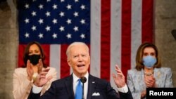 El presidente Joe Biden, se dirige al Congreso entre los aplausos de la vicepresidenta Kamala Harris y de la presidenta de la Cámara de Representantes, Nancy Pelosi, el 28 de abril de 2021.